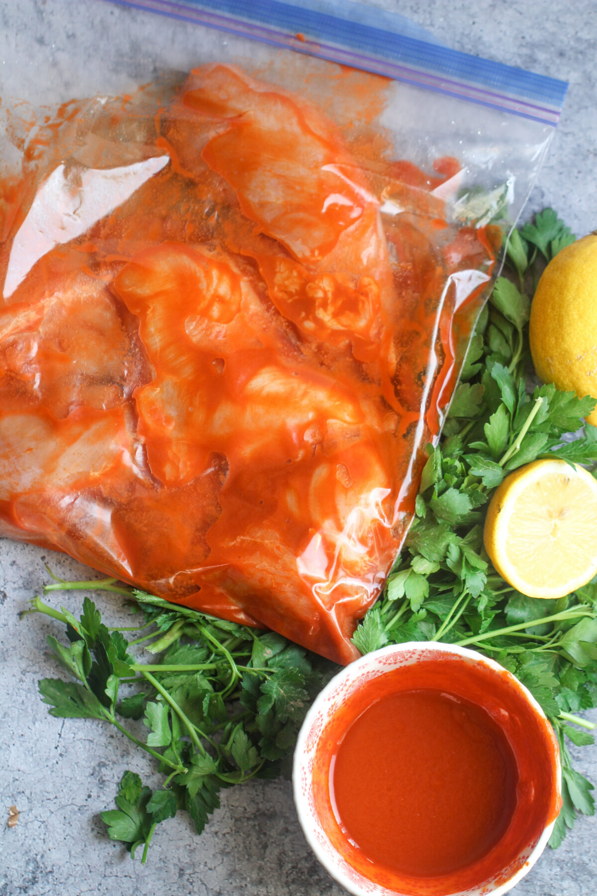 Chicken marinating in the peri peri sauce in a resealable plastic bag.