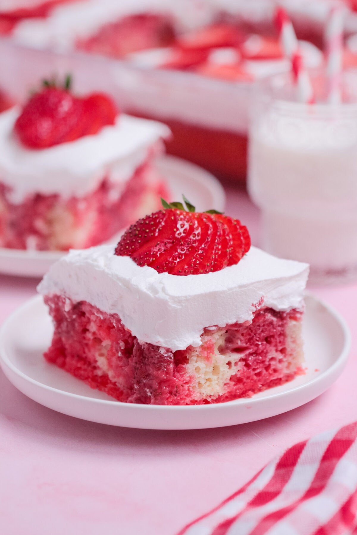 Strawberry Poke Cake is a sweet and creamy dessert with strawberry Jell-O, homemade strawberry sauce, white cake, and whipped topping.