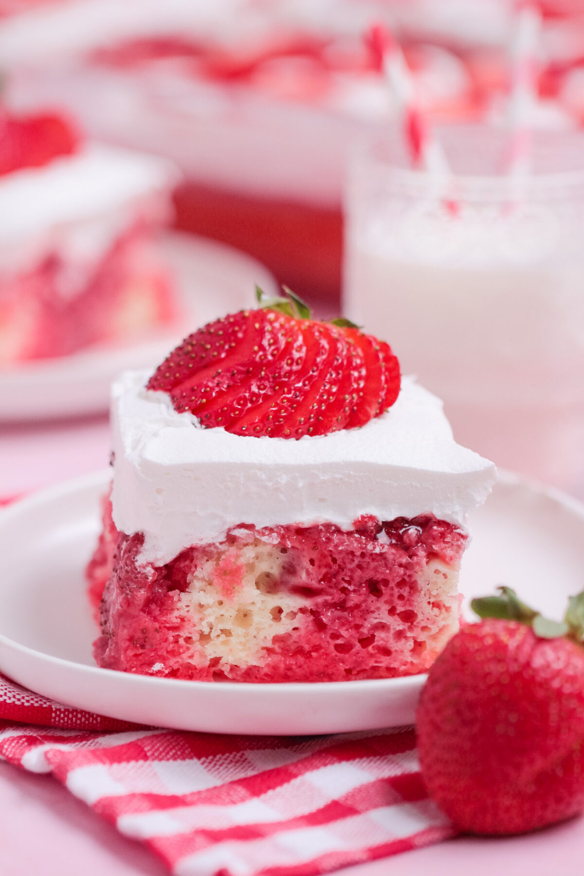 Strawberry Poke Cake is a sweet and creamy dessert with strawberry Jell-O, homemade strawberry sauce, white cake, and whipped topping.