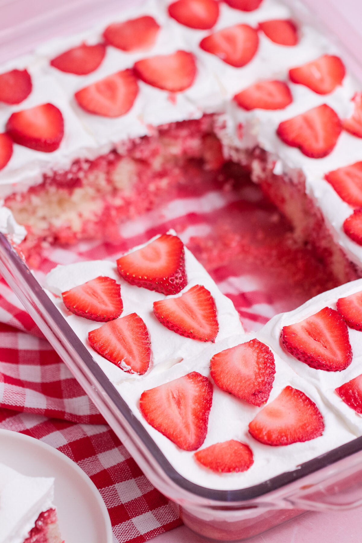 Strawberry Poke Cake is a sweet and creamy dessert with strawberry Jell-O, homemade strawberry sauce, white cake, and whipped topping.