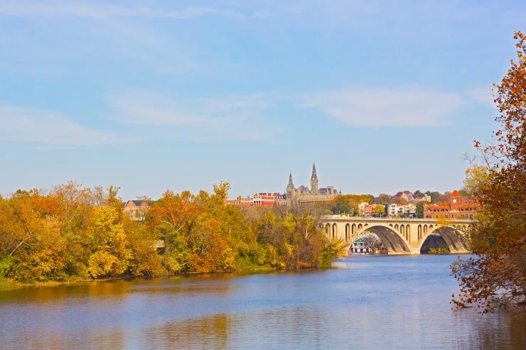 Fall colors of Potomac riverside and Key Bridge, Washington DC. A view on Georgetown University across Potomac River in autumn. 