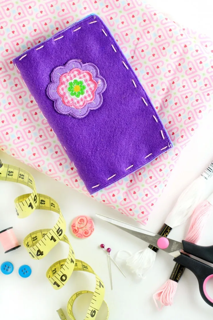 Keep your pins and needles on hand and completely organized in this beautiful handmade felt needle case. A great gift idea for anyone who loves sewing, it is designed like a book with a cover and pages inside for holding pins and needles.