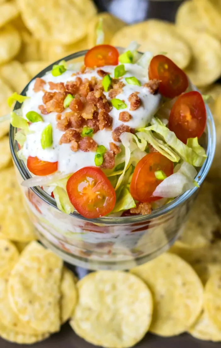 Fans of bacon, lettuce and tomato sandwiches will fall for this creamy, layered and easy BLT Dip recipe. Salty, crisp bacon and fresh tomatoes in a creamy dip make this BLT Dip recipe amazing. Perfect easy appetizer to serve at parties!