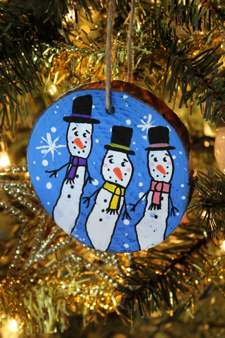 These Wood Slice Fingerprint Snowmen Ornaments are an adorable and festive holiday craft that make for great keepsake gifts that look great on a Christmas tree. We had so much fun making these Christmas ornaments!