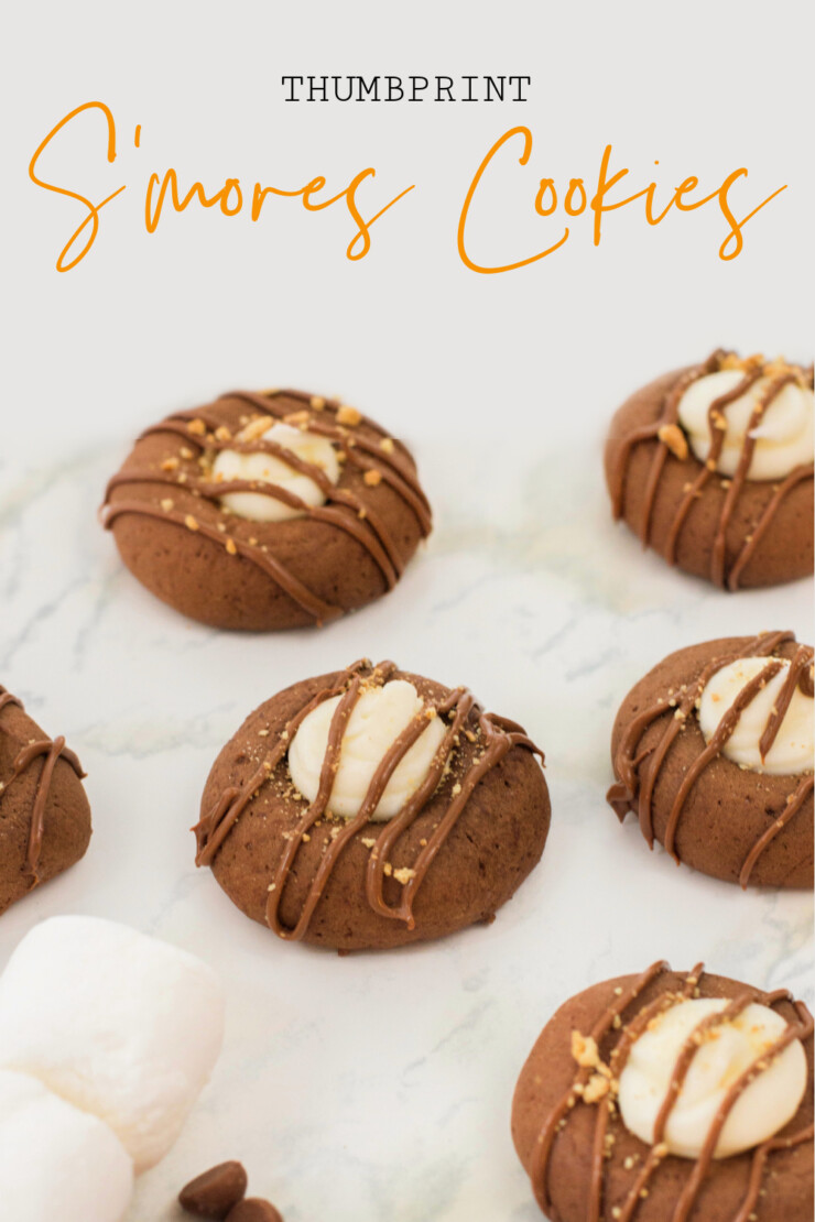 These easy to make S'mores Thumbprint Cookies features all the flavours of that favourite summertime camping treat.  A delectable chocolate cookie filled with marshmallow and topped with graham crackers and a chocolate drizzle.