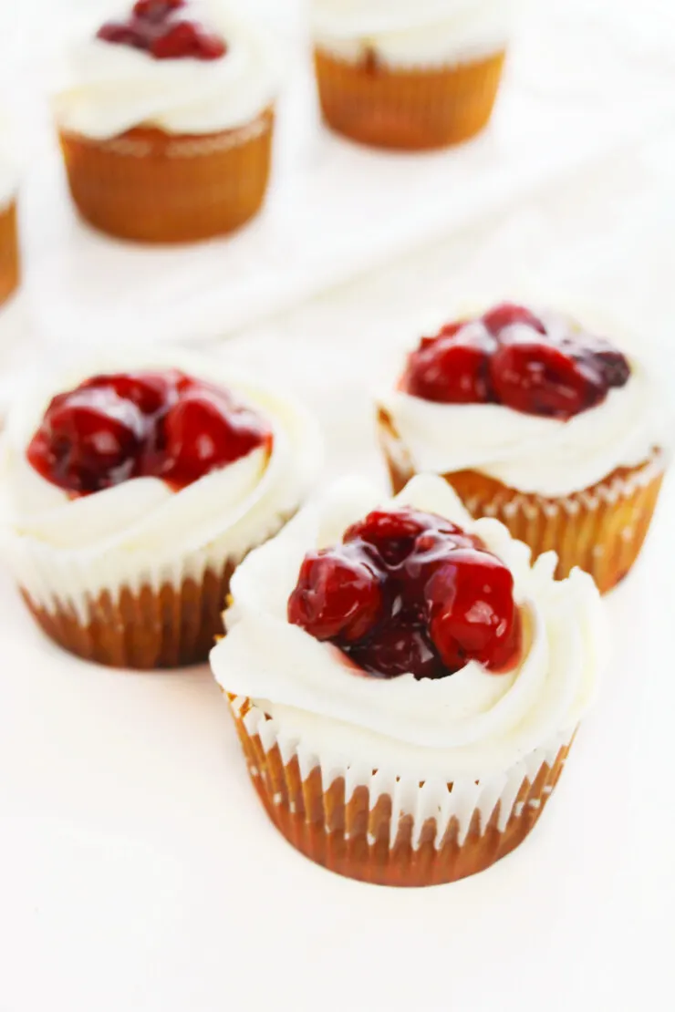 These Cherry Pie Cupcakes feature a decadent vanilla cinnamon cupcake filled with cherry pie filling and topped with vanilla cinnamon buttercream and even more cherry filling! These cupcakes are bursting with all the flavours of a delicious cherry pie!