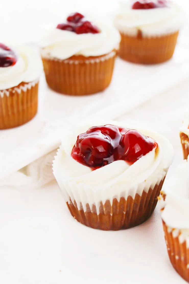 These Cherry Pie Cupcakes feature a decadent vanilla cinnamon cupcake filled with cherry pie filling and topped with vanilla cinnamon buttercream and even more cherry filling! These cupcakes are bursting with all the flavours of a delicious cherry pie!