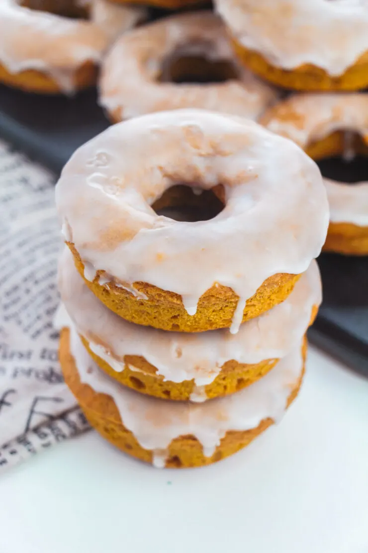 An easy recipe for Baked Pumpkin Donuts that results in soft fluffy and flavourful cake donuts without yeast in just 30 minutes. Coated in a simple vanilla glaze to perfectly complement the pumpkin spice flavours.