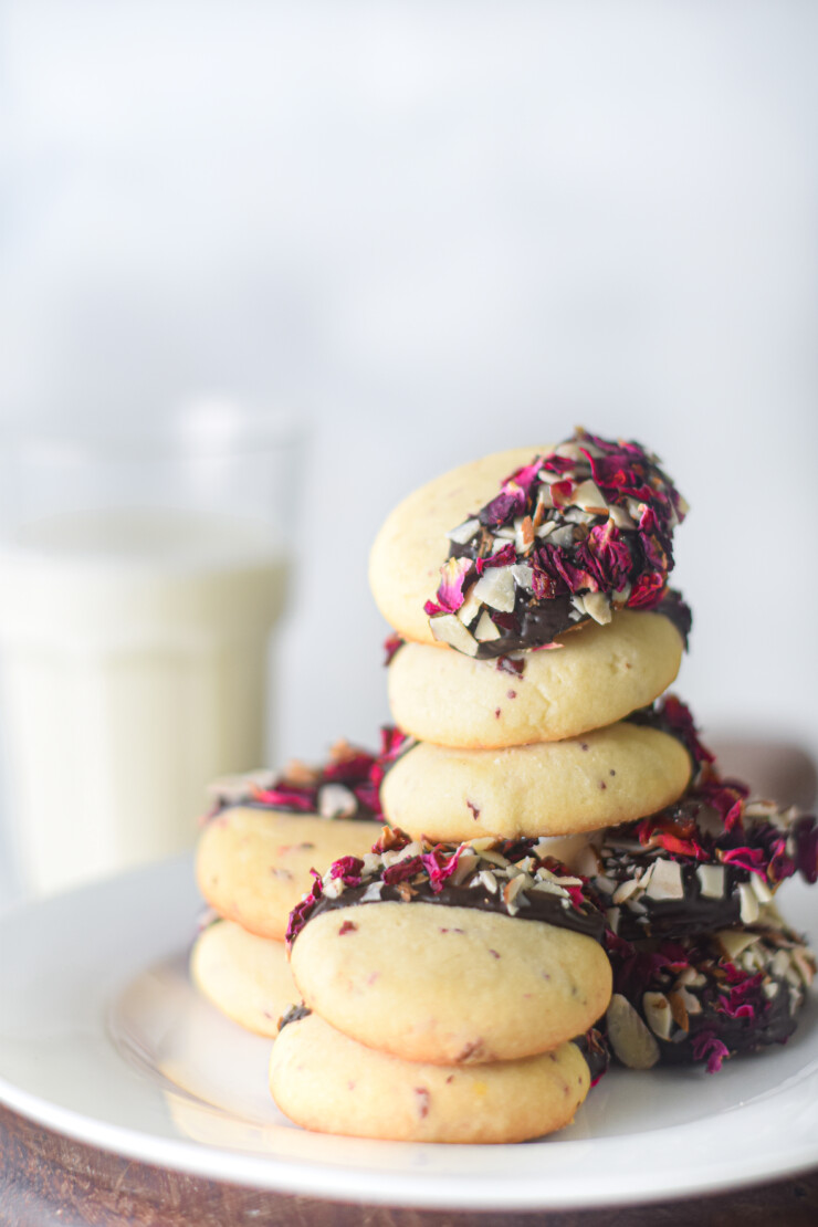 Fragrant Vanilla & Rose Shortbread Cookies are dipped in chocolate and sprinkled with rose petals and almonds in this tasty cookie recipe.