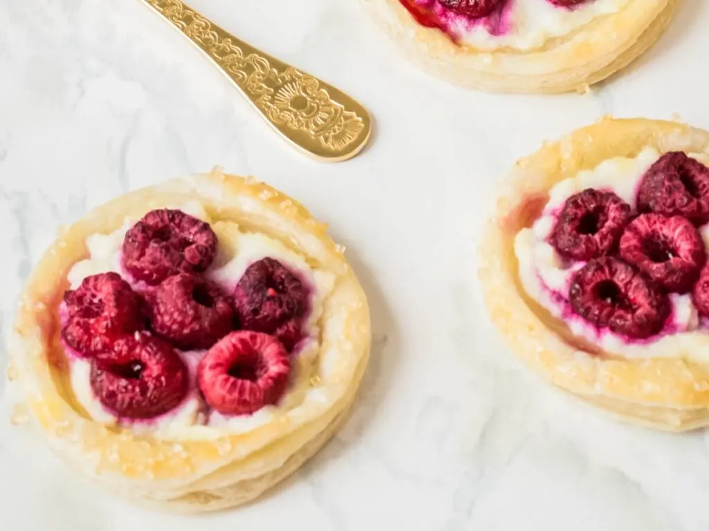 These Puff Pastry Raspberry Danishes are an easy to make breakfast pastry featuring puff pastry, fresh raspberries and a luscious ricotta filling.