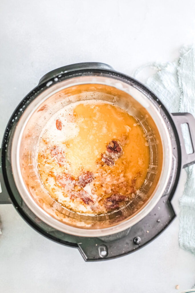 Butter bubbling inside instant pot with pecans.