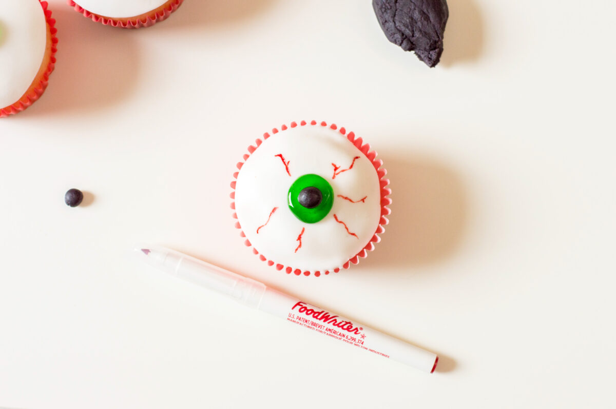 Drawing veins on the eyeballs with edible food marker.