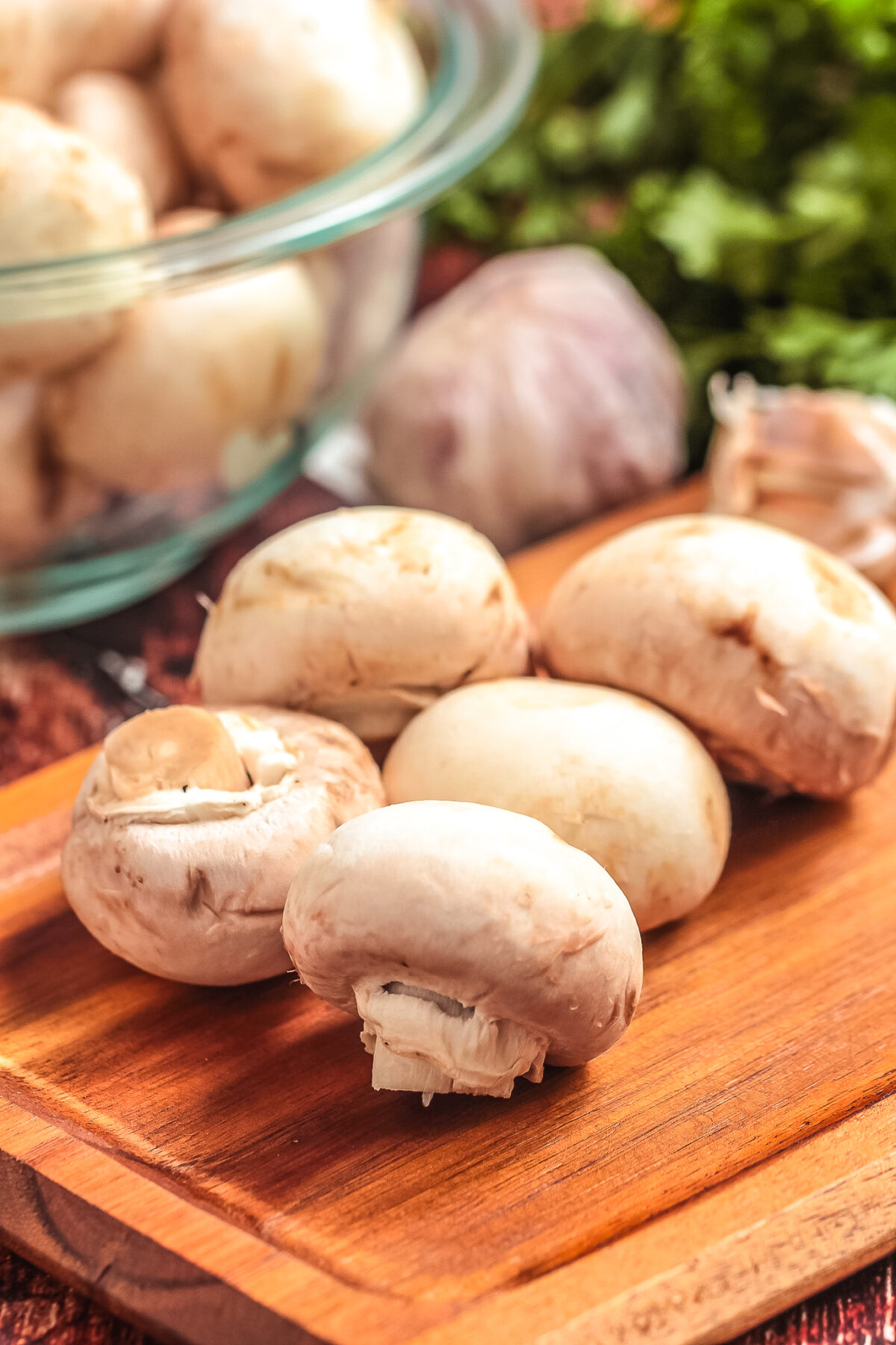 White button mushrooms on a cutting board.