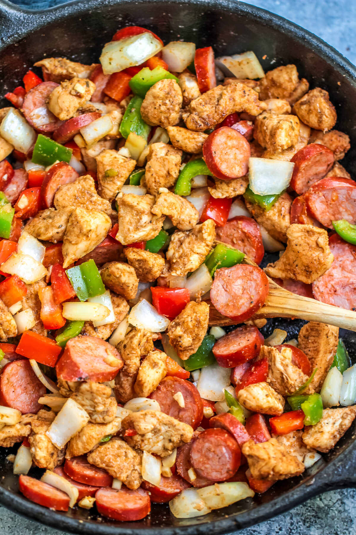 Chicken and veggies cooking in skillet.