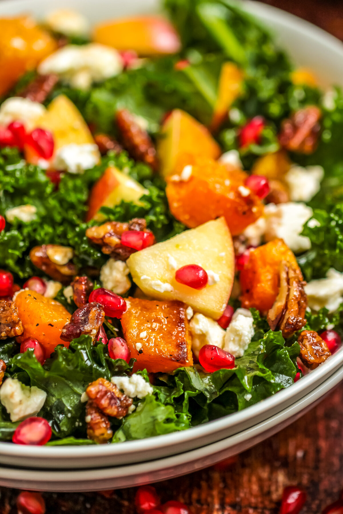 A beautiful salad that's perfect for fall, this Roasted Butternut Squash & Apple Salad recipe features candied pecans and feta cheese.