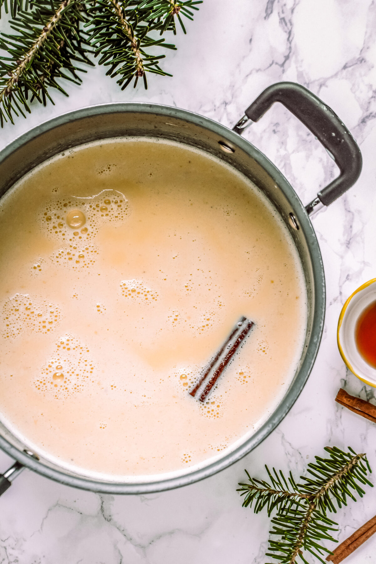 Eggnog cooked until thickened in a large pot.