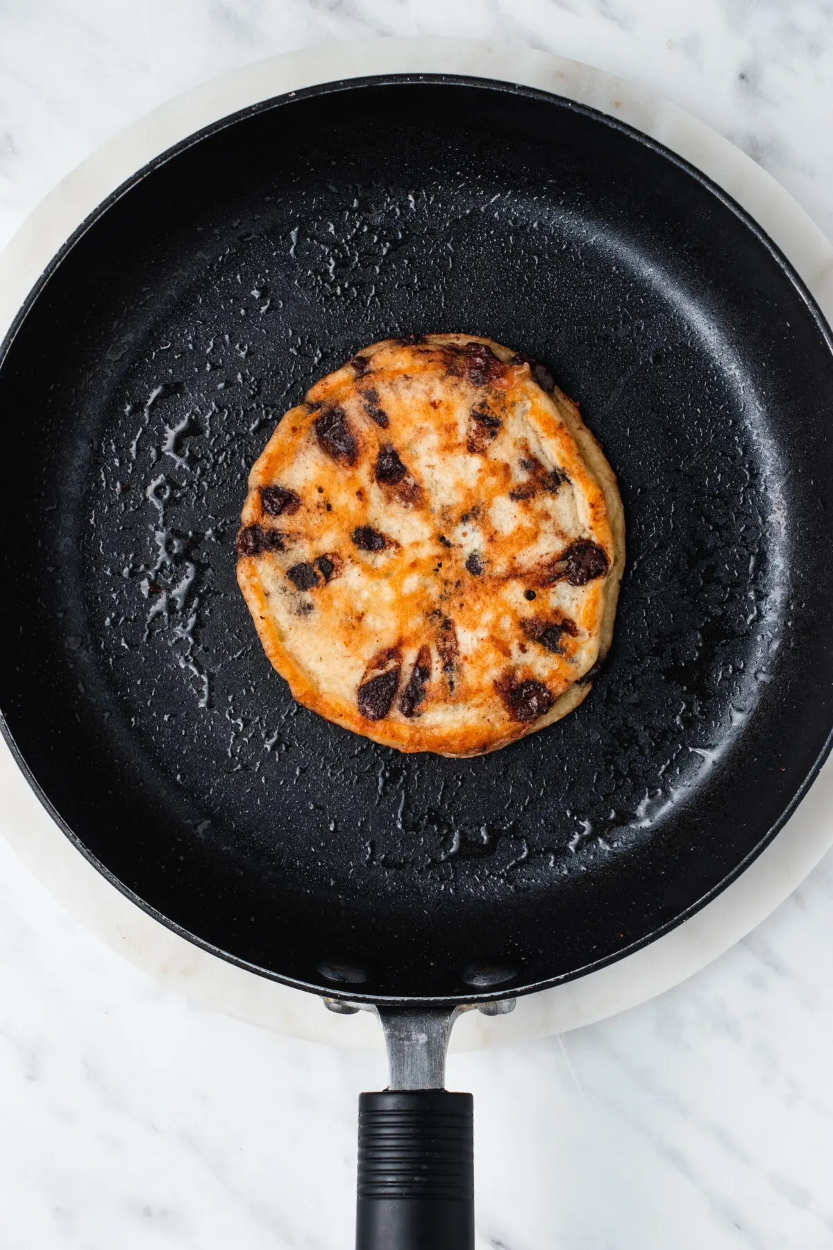 Cooked pancake in a greased pan.
