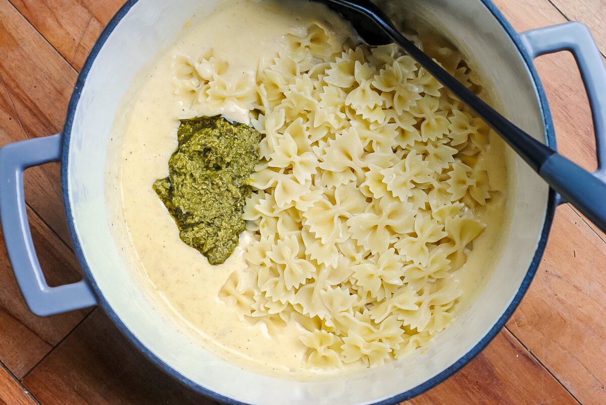 Making Pesto mac and cheese... pasta, cheese roux and pesto in a large pot.