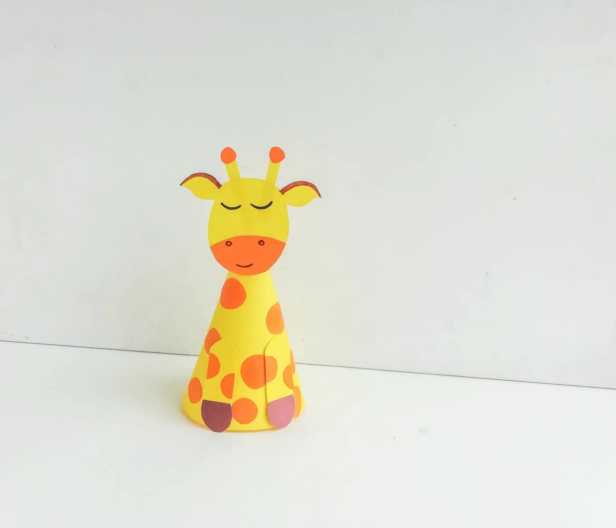 This fun paper giraffe craft for kids includes a free printable template that makes it easy to create a cone-shaped giraffe that stands tall!