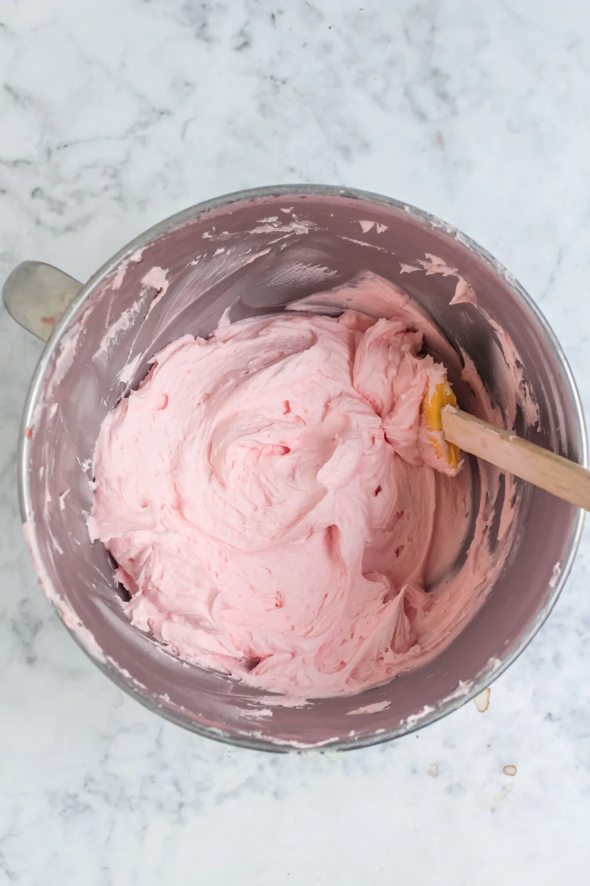 Cherry frosting in a stand mixer bowl.