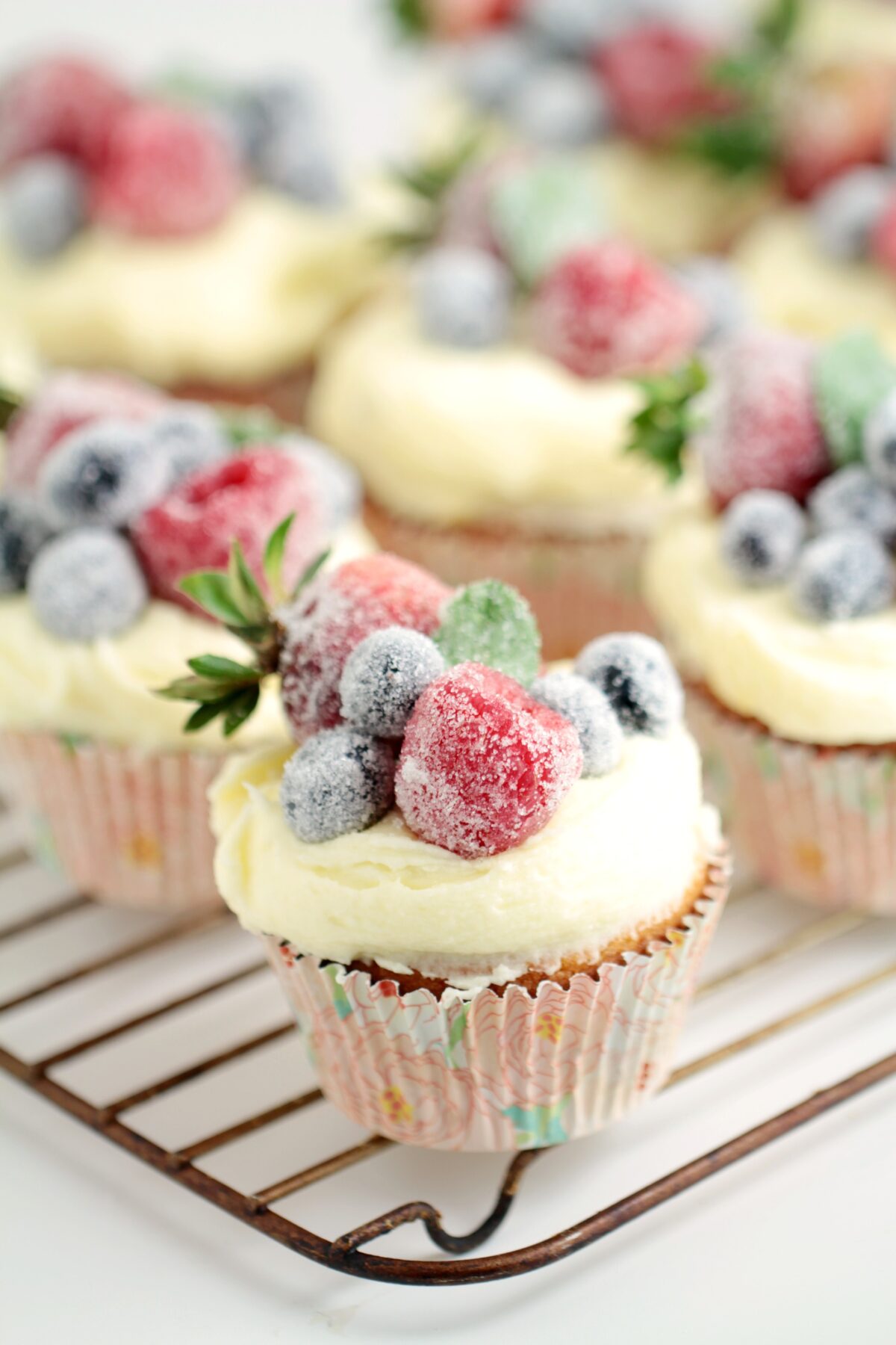 Frosted Berry Cupcakes with an Orange Mascarpone Buttercream feature a fluffy orange cake topped with a luscious frosting, and sugared fruit.