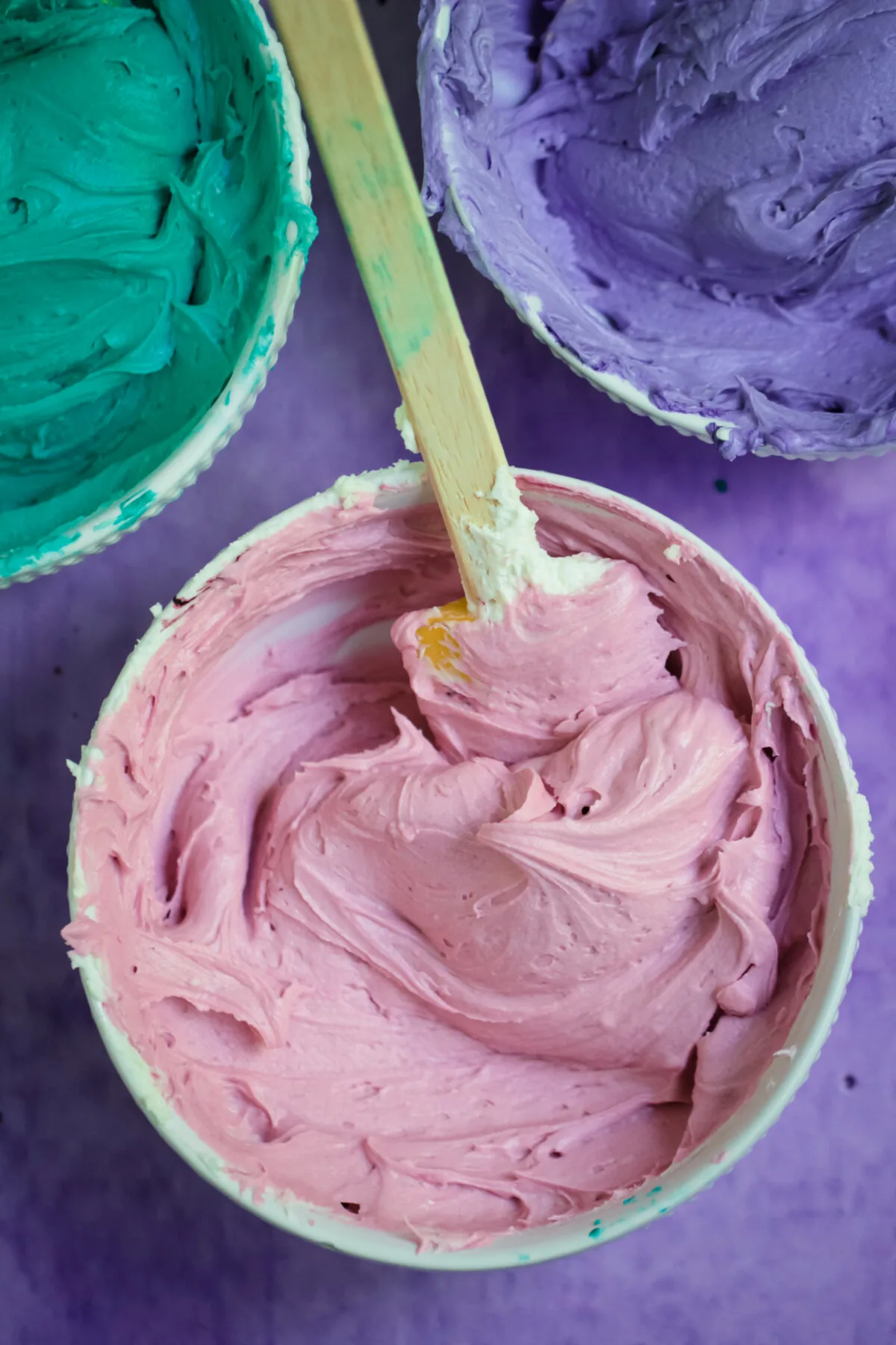 Colourful frosting in bowls.