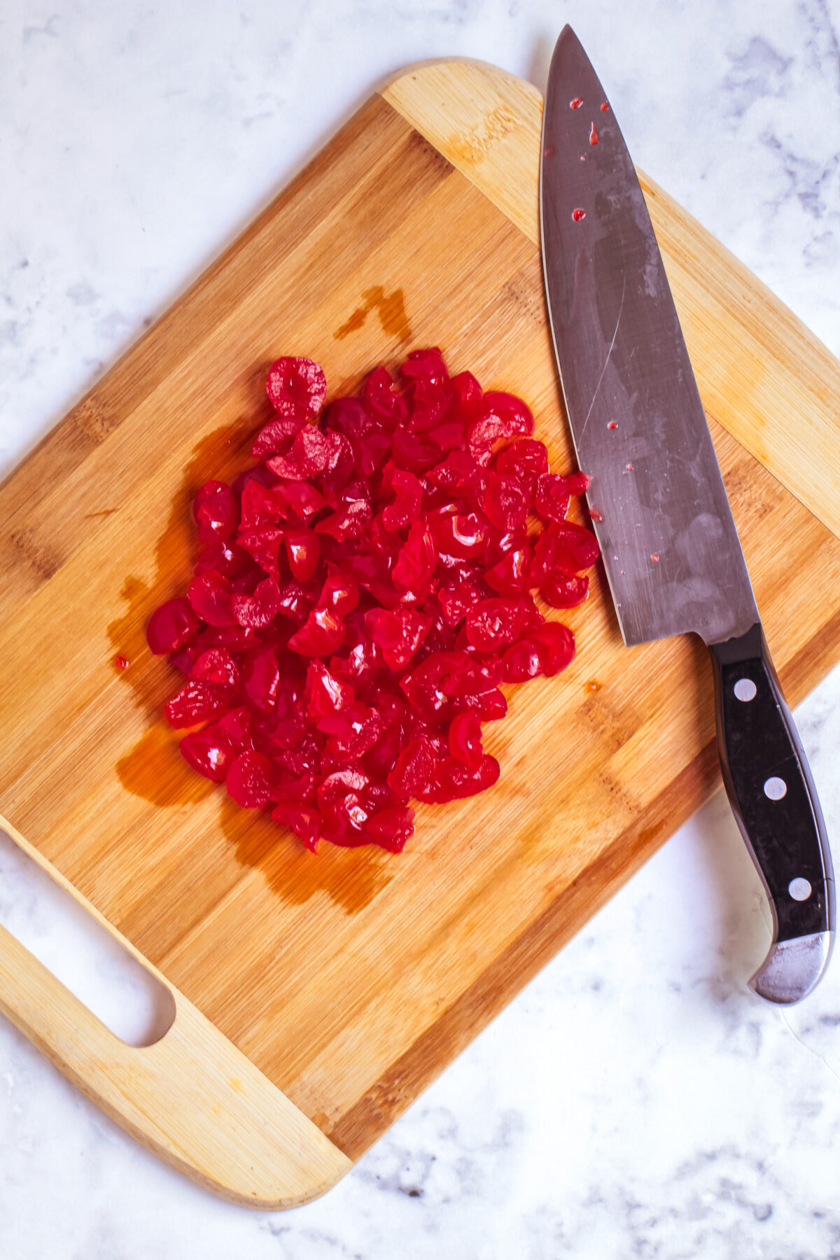 Cherries chopped up on a cutting board.