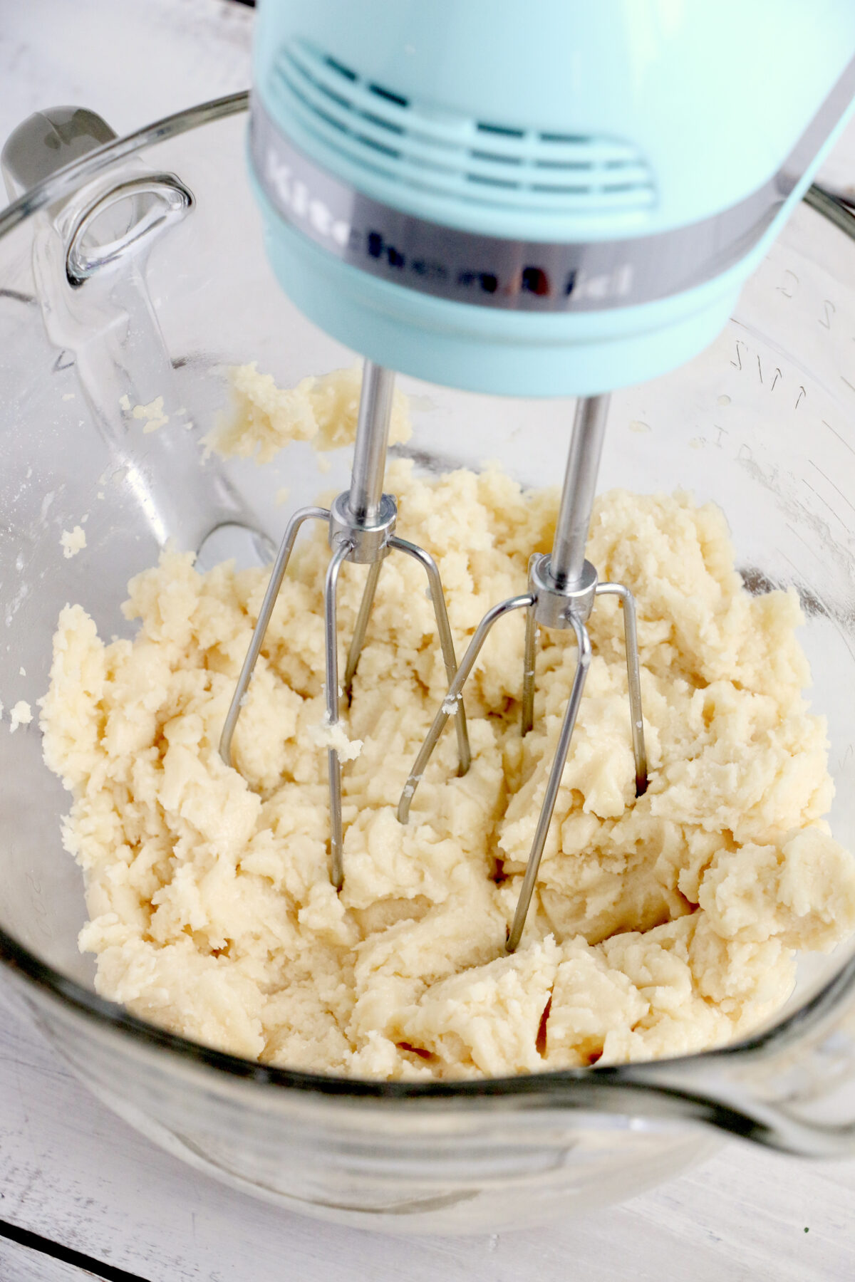 Cake batter being mixed with an electric mixer.