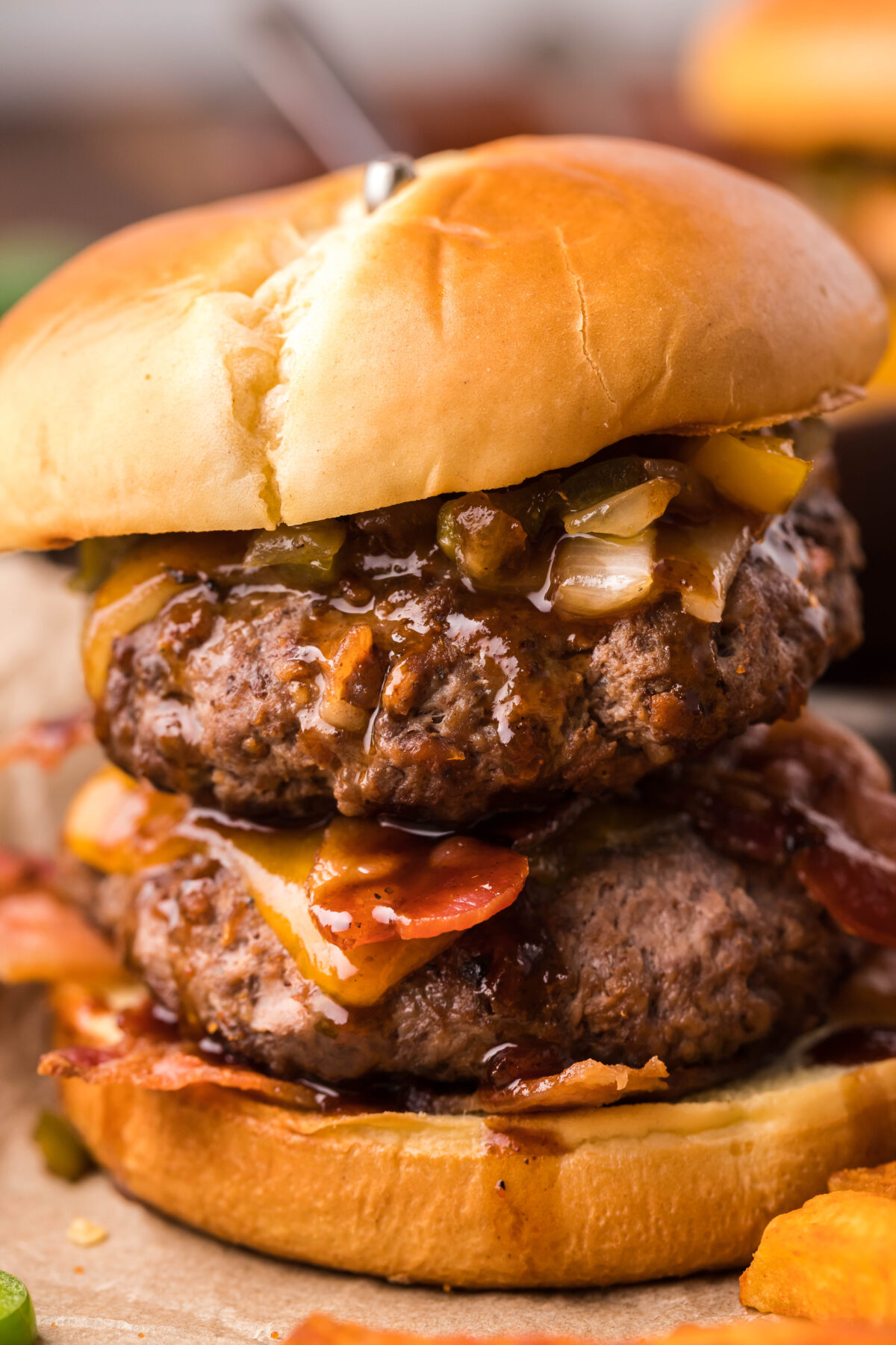 This sweet n spicy bacon burger recipe is easy to make and features caramelized onions and peppers with an amazing sweet n spicy bbq sauce.