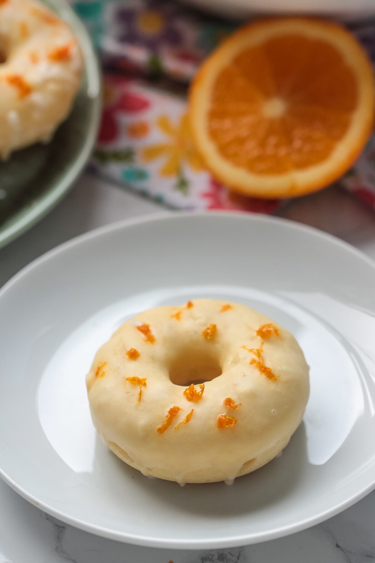 Love homemade donuts? Check out this delicious and easy to follow recipe for orange glazed cake donuts! They can be baked or fried!