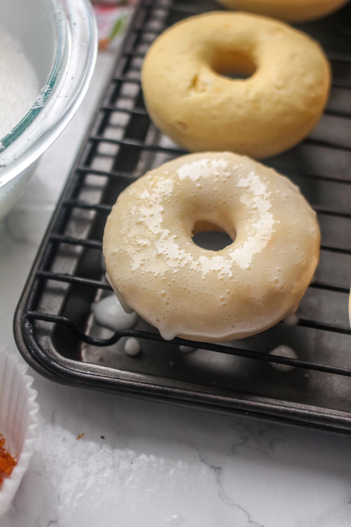 Glazed donut on cooling rack, with glaze not set.