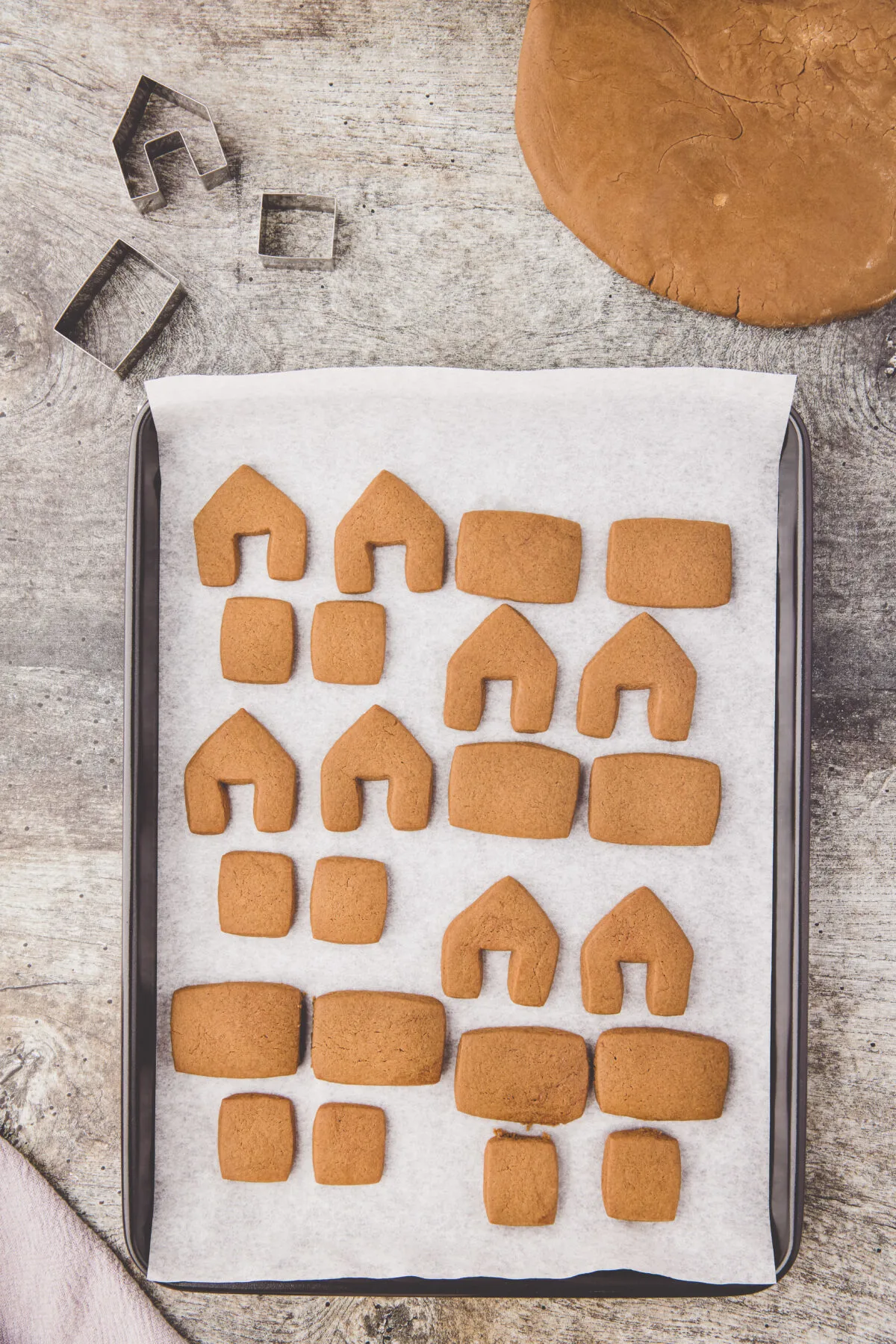 Gingerbread pieces baked on a baking sheet.