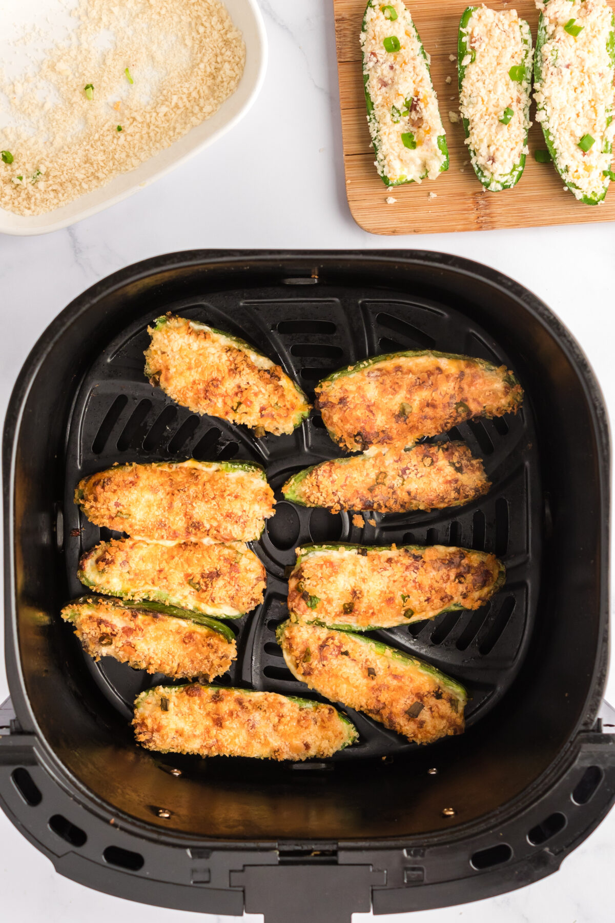 Jalapeno poppers in the bottom of an air fryer.