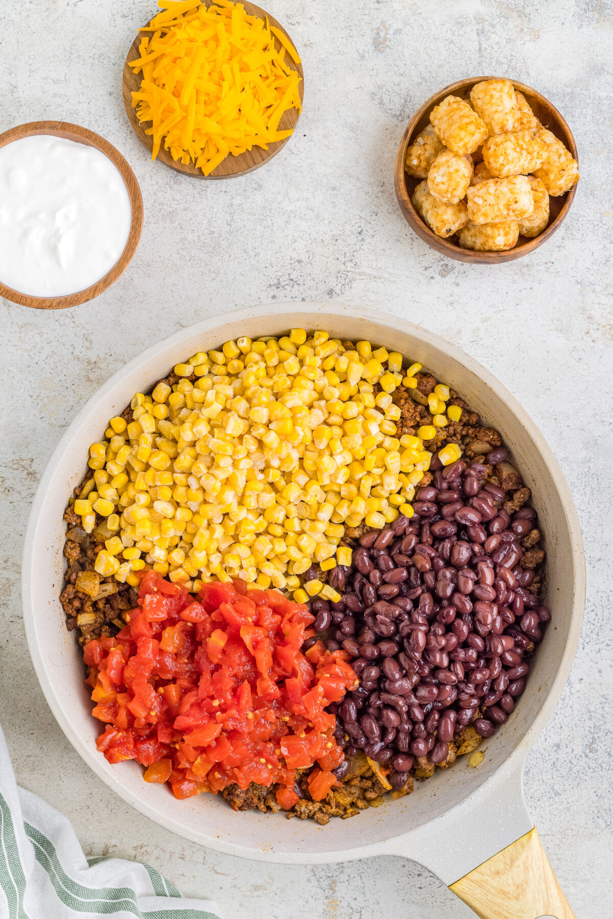 Corn, tomatoes, and beans added to the skillet.
