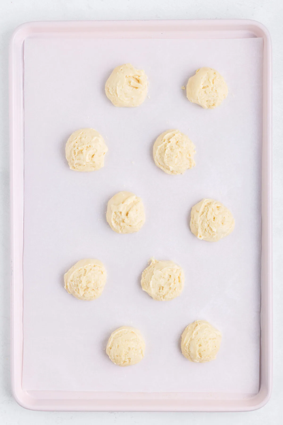 Dough balls on a baking sheet lined with parchment paper.