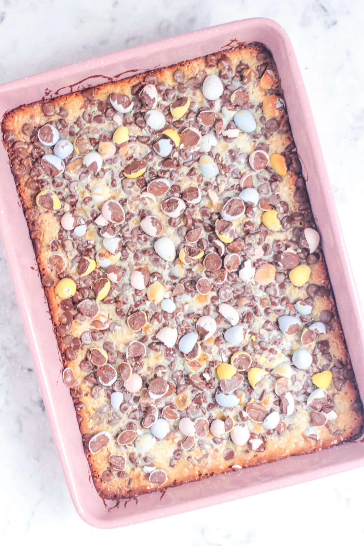 Magic cookie bar straight out of the oven and sprinkled over with more mini eggs.