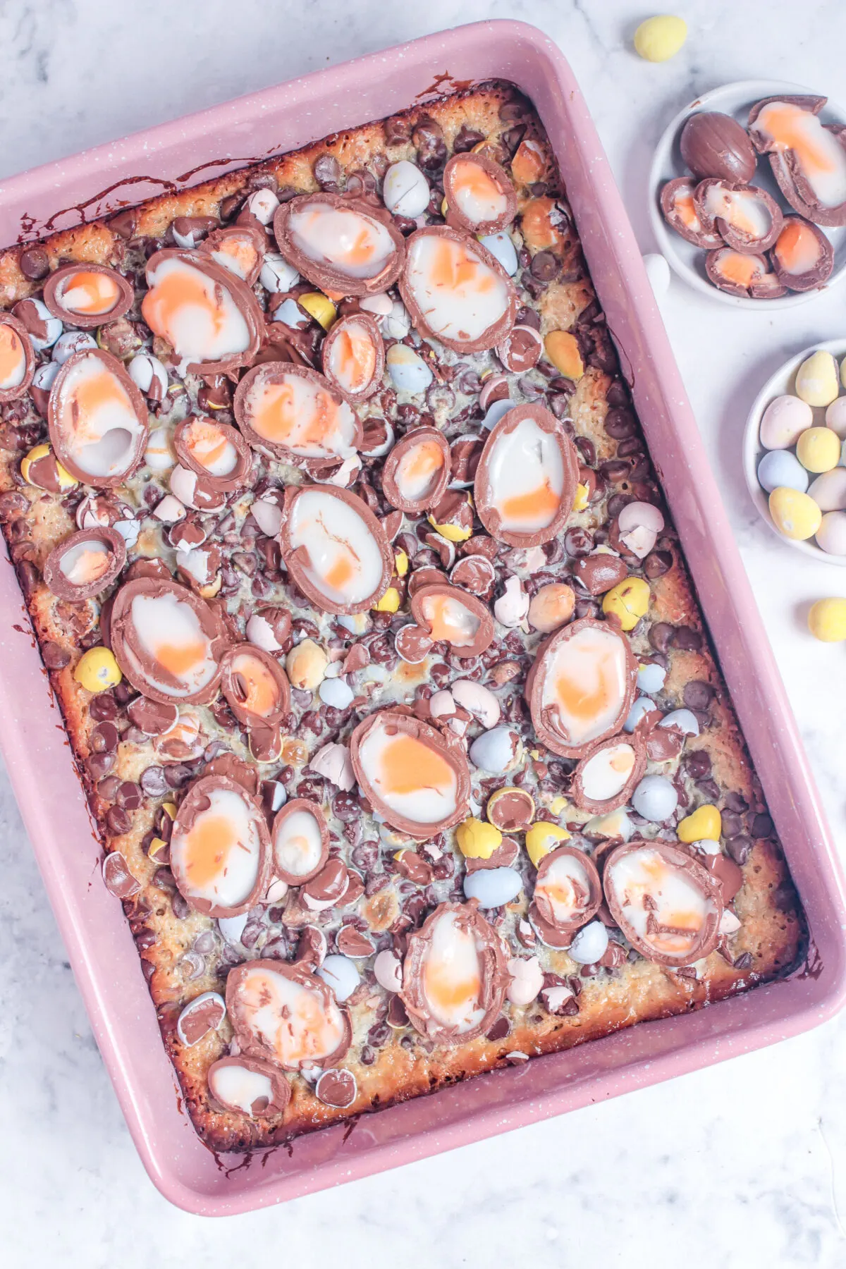 Magic cookie bar topped with halved creme eggs.