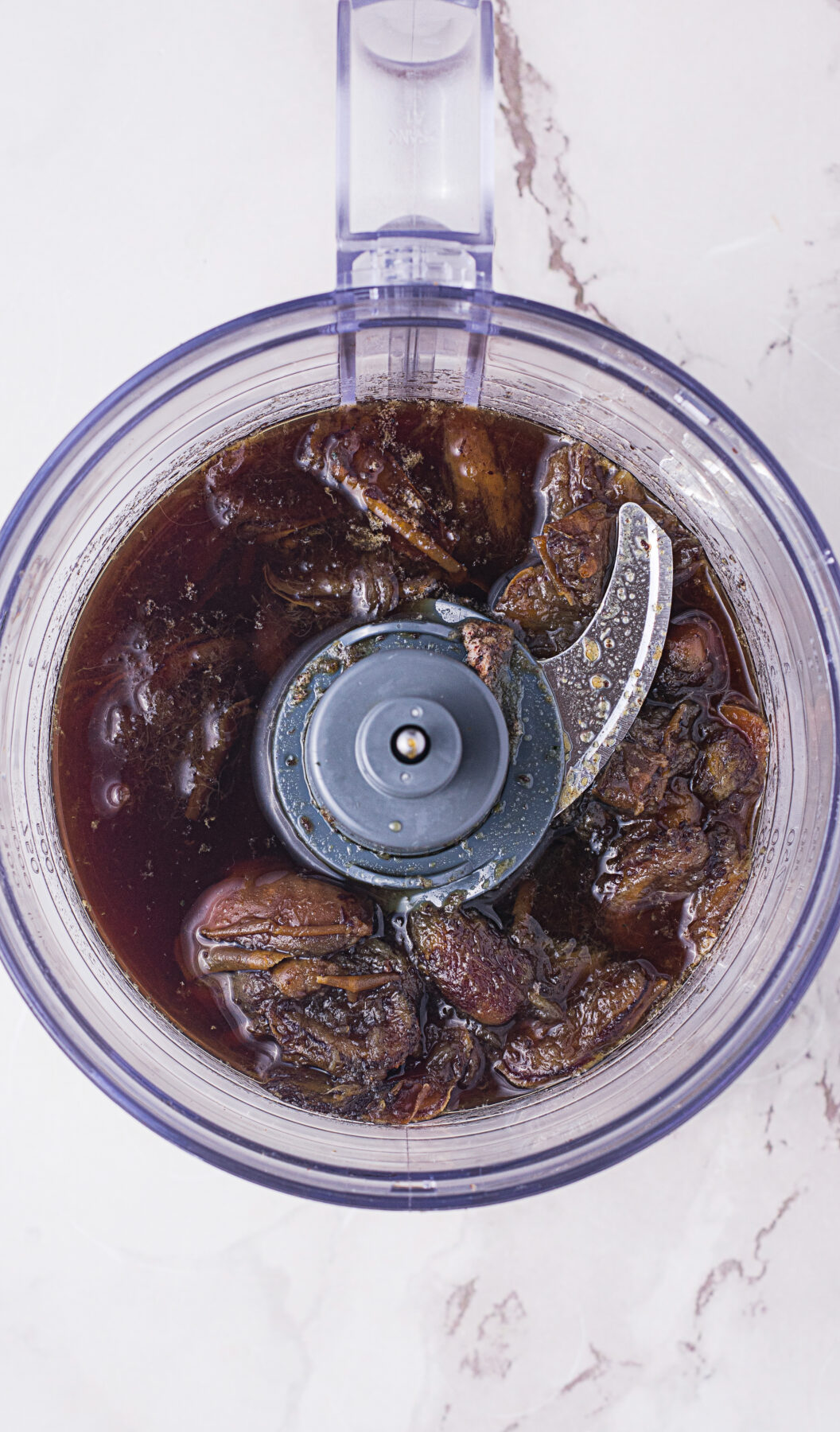 Dates, baking soda, and cooking water in a food processor.