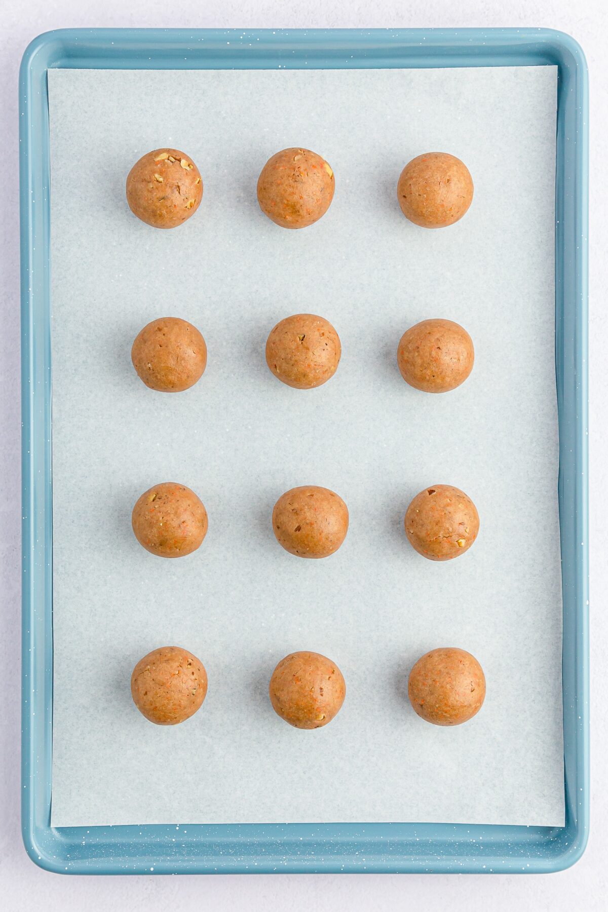 Carrot cake mixture rolled into balls and placed on a baking sheet.
