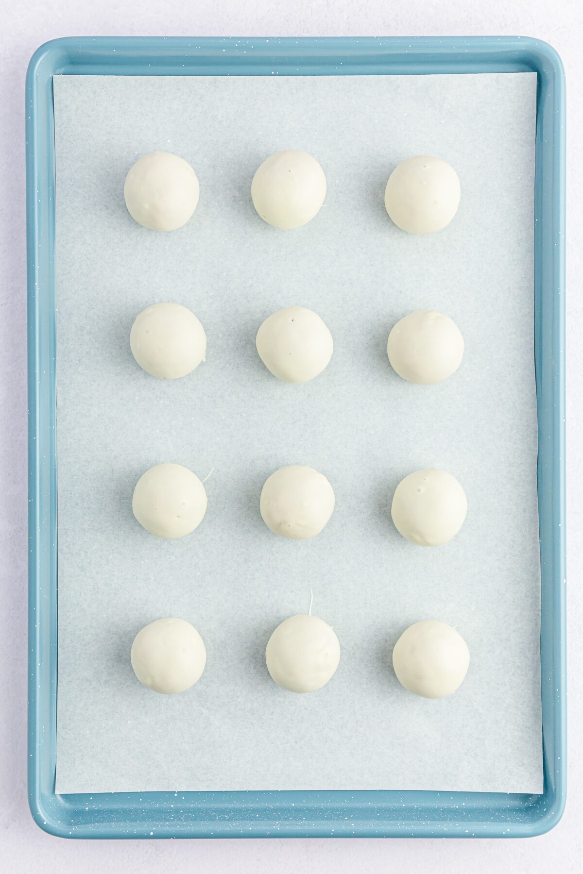 Chocolate coated carrot cake balls on a baking sheet.