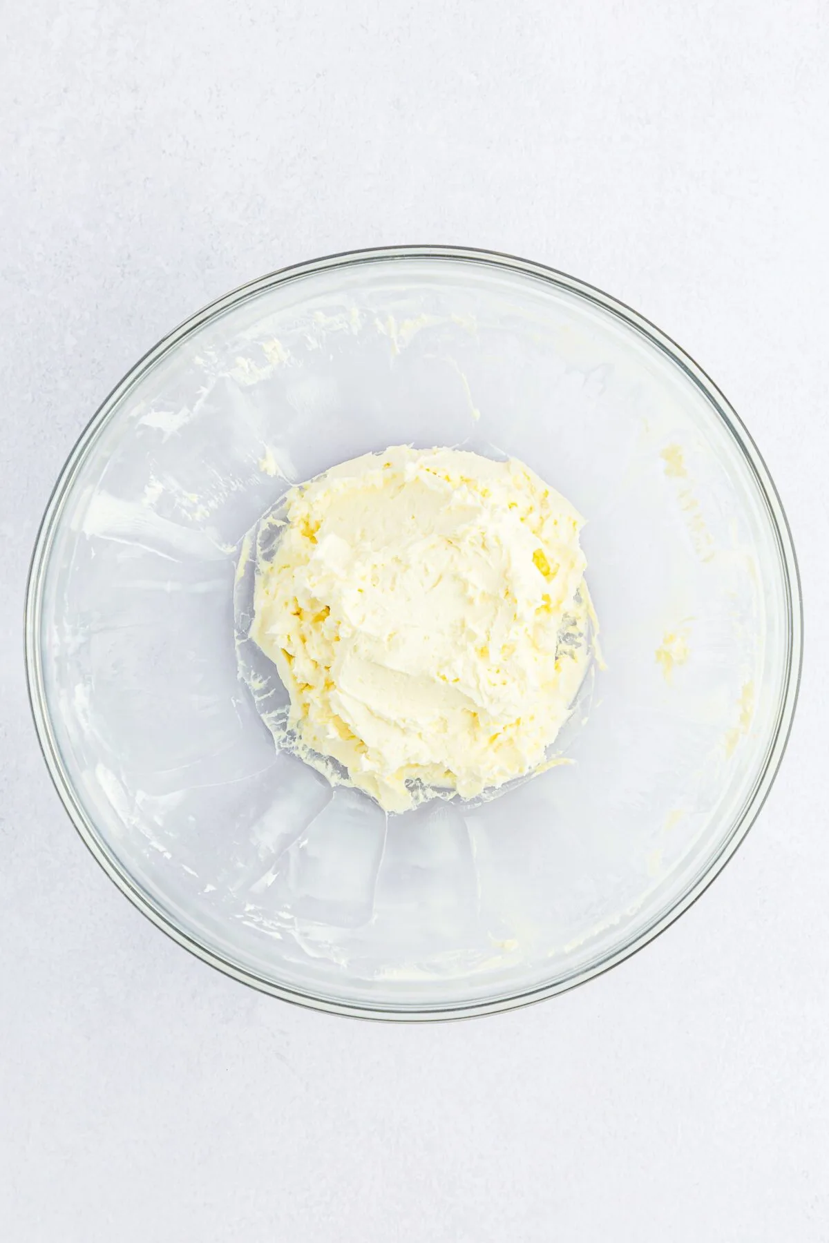 Cream cheese beat until smooth and creamy in a glass bowl.