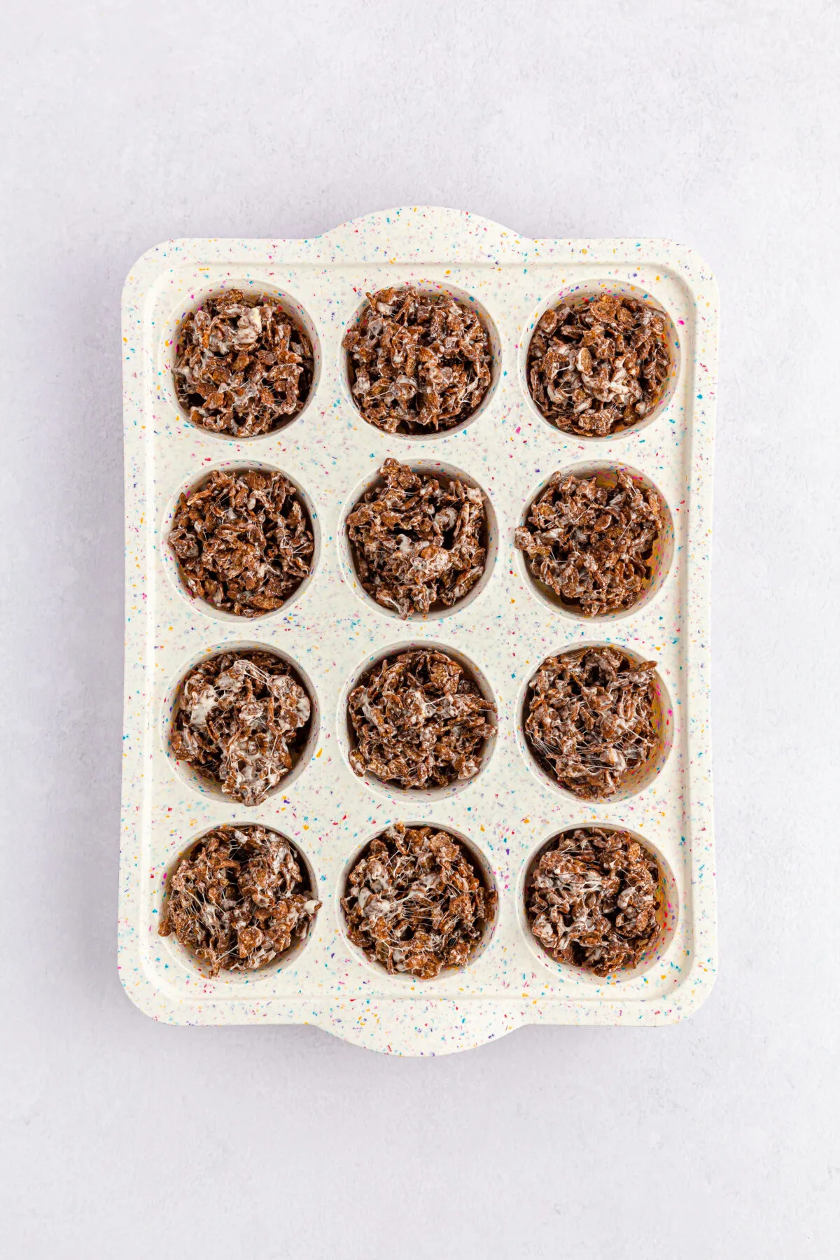 Cocoa pebbles mixture pressed into a muffin pan.