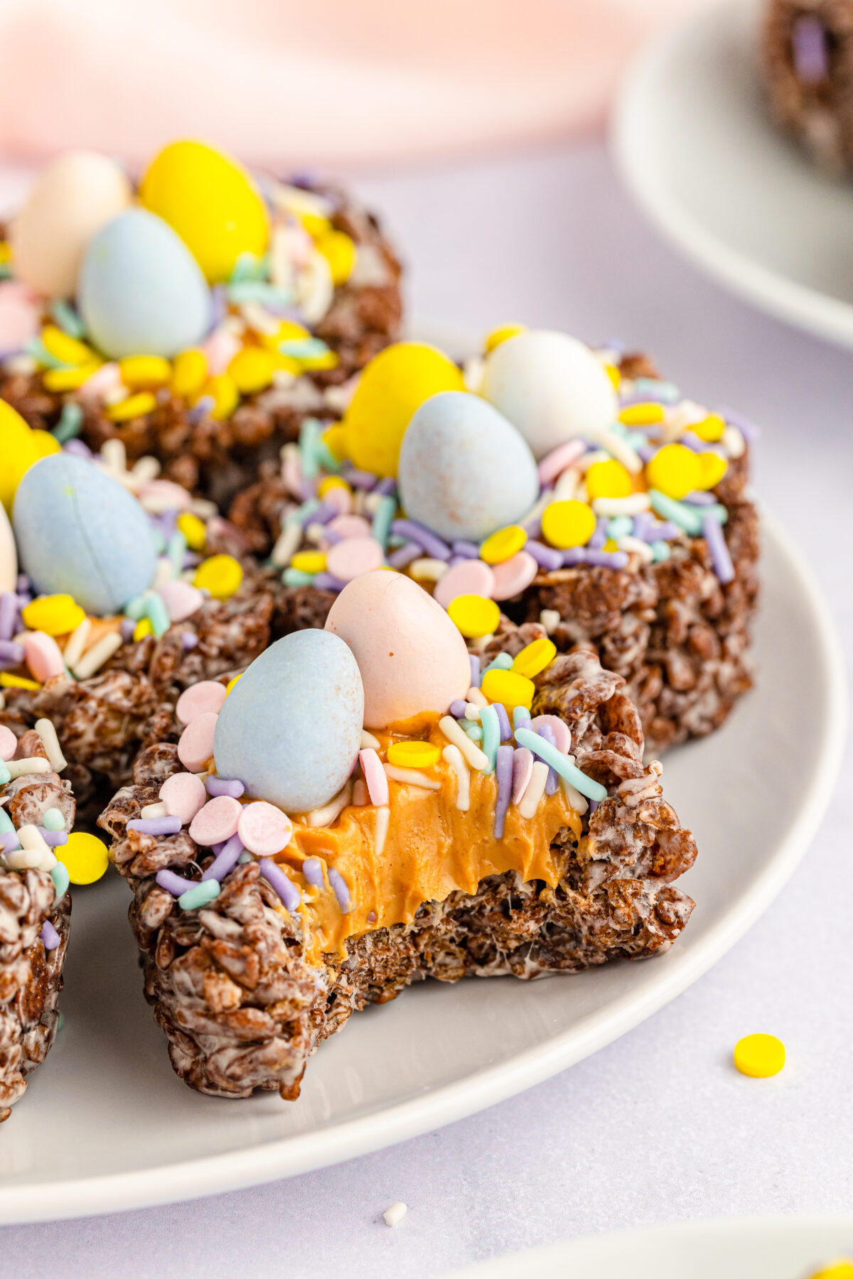Celebrate this Easter with these Cocoa Pebbles Easter Nests filled with creamy peanut butter and topped off with chocolate eggs.