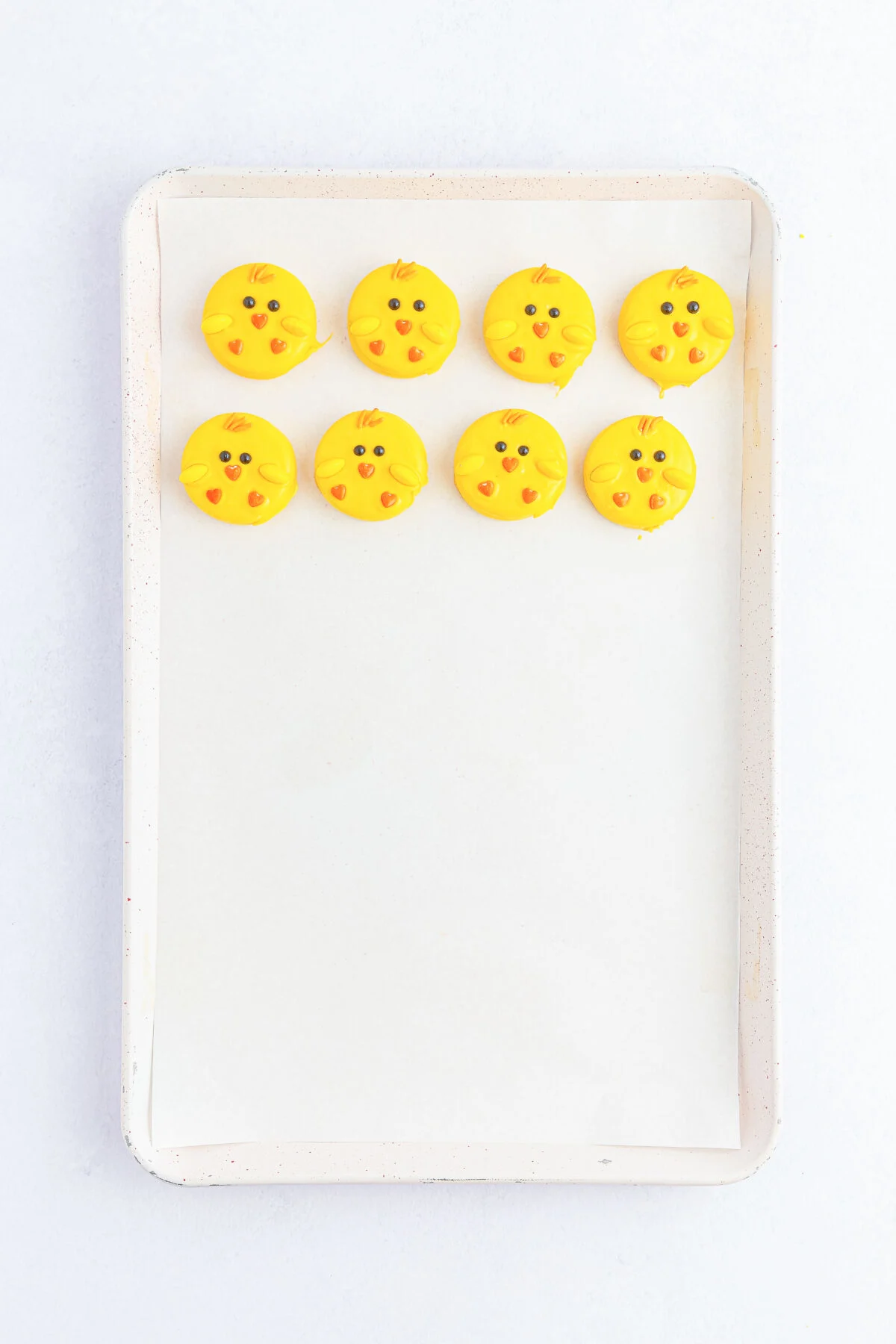 8 yellow chicks on a sheet pan.