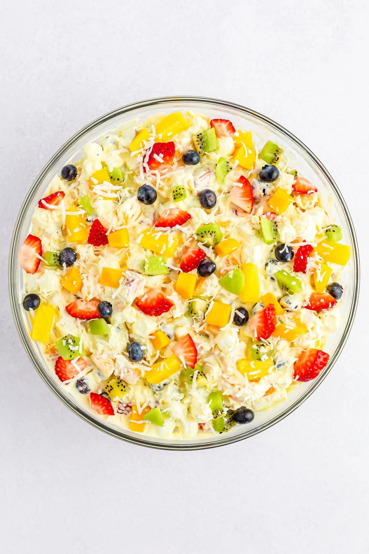 Tropical fruit fluff salad topped with more fruit and coconut.