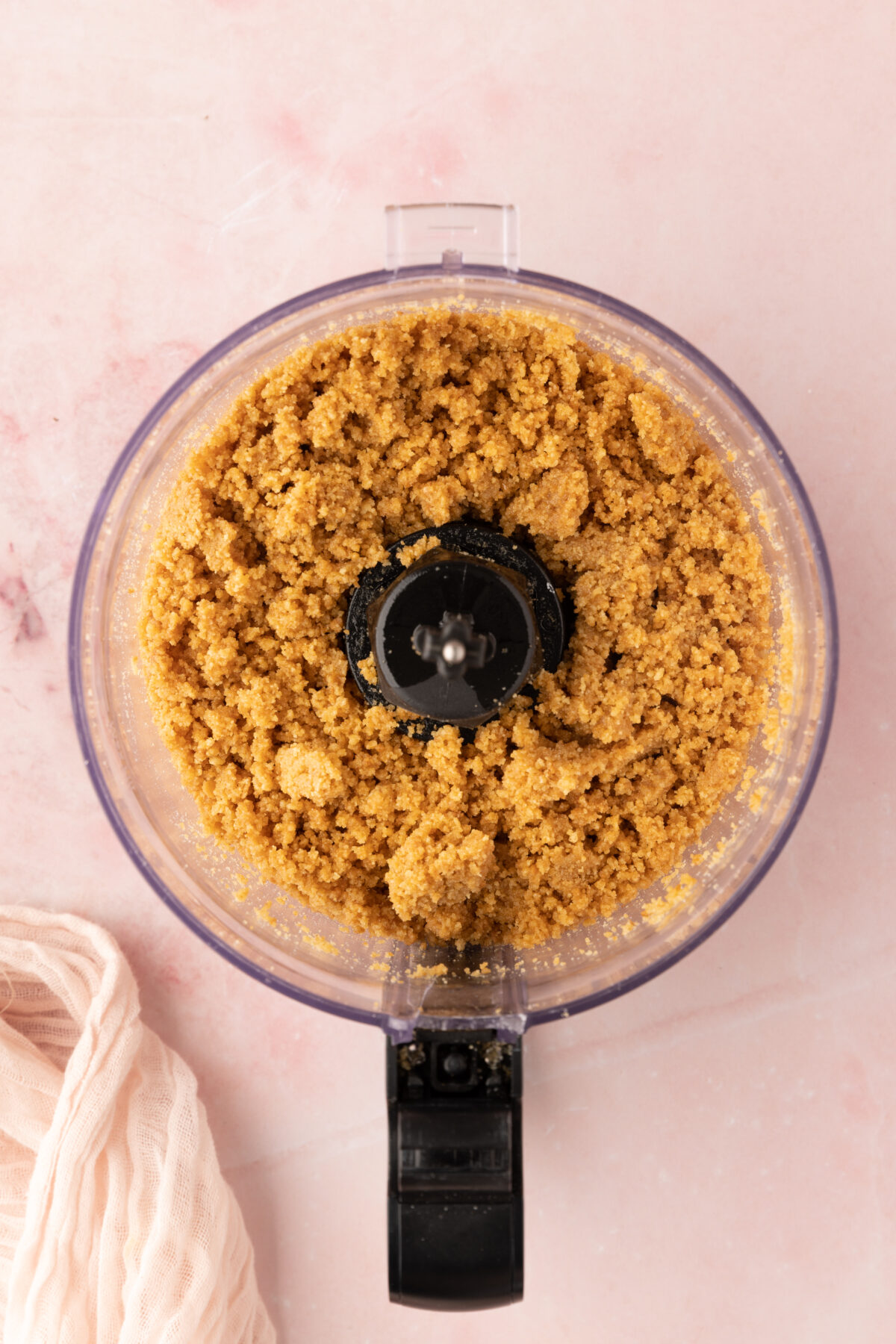 Graham crumbs, butter, and brown sugar combined in a food processor.