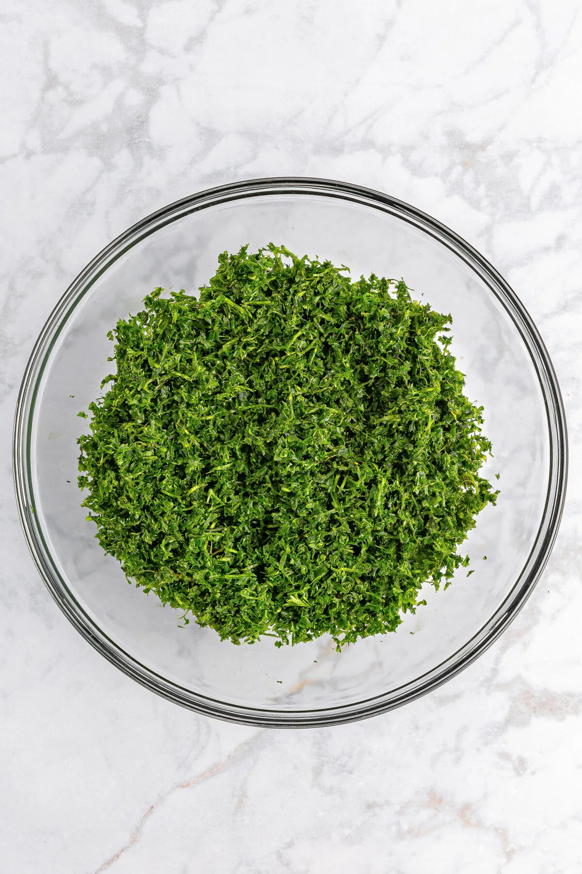 Finely chopped parsley and mint in a large mixing bowl.