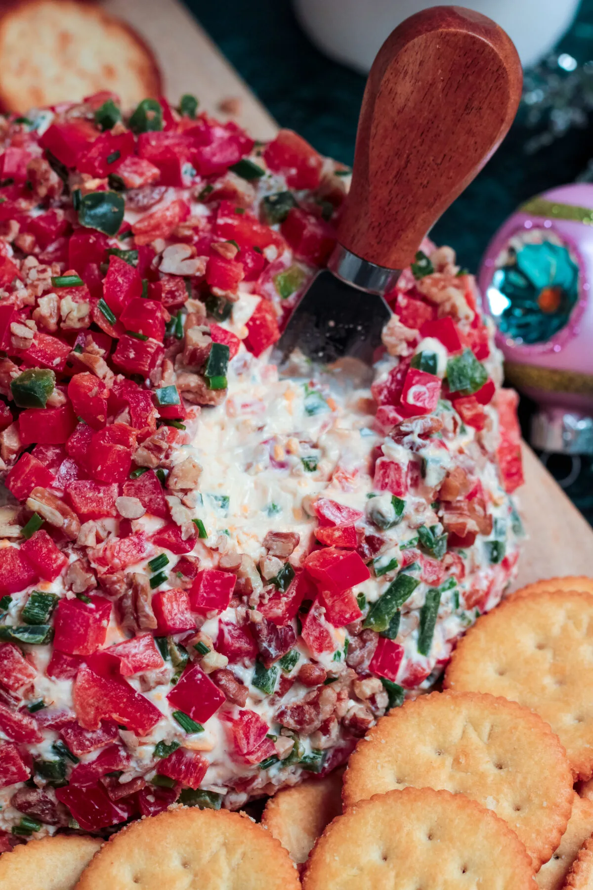Celebrate the holidays with this simple recipe for a Christmas cheese ball made with sharp cheddar, bell peppers, pecans, and more!