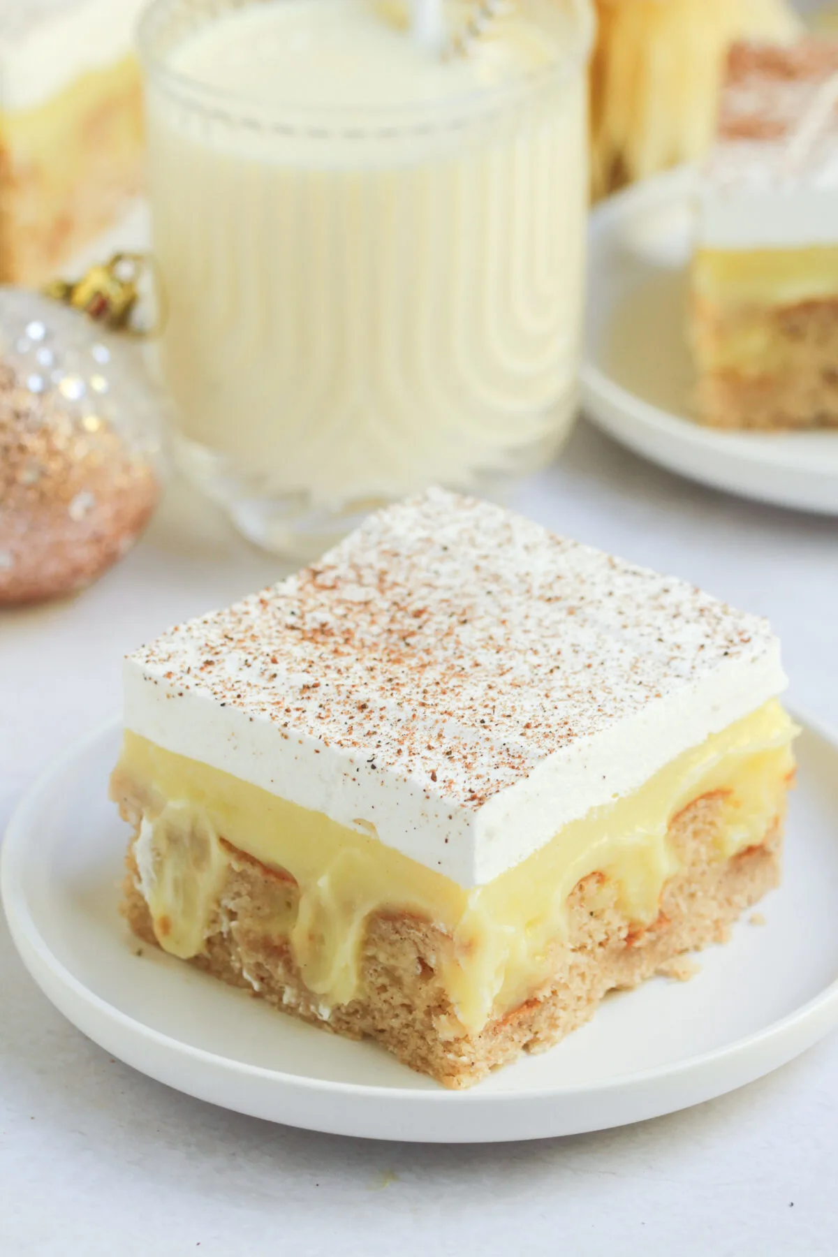 Celebrate the holidays with this eggnog poke cake topped with a creamy eggnog pudding filling and whipped topping dusted with nutmeg.