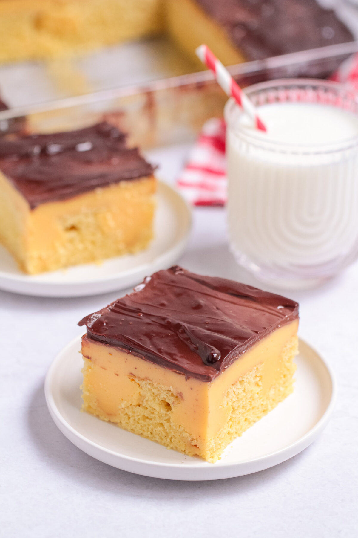 This Boston Cream Poke Cake features yellow cake, classic vanilla custard, and chocolate ganache for a nostalgic bakery-inspired dessert.